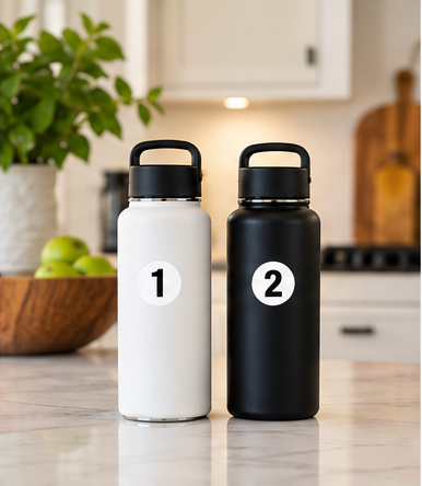 Matching white and black water bottles on a kitchen counter, tagged 1 and 2